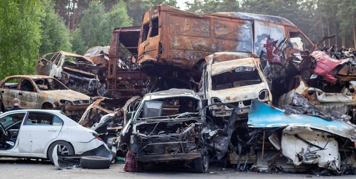 A lot of rusty burnt cars in Irpen, after being shot by the Russian military. Russia's war against Ukraine. Cemetery of destroyed cars of civilians who tried to evacuate from the war zone