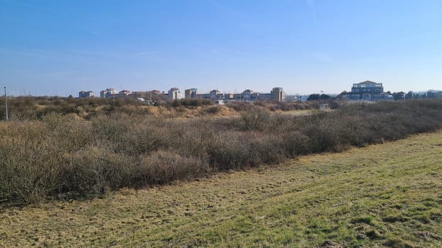 View of the resort of Port Zelande and its surroundings of the lake and dunes under a partly blue sky