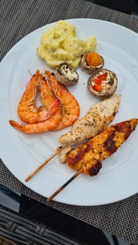 Grilled meat on wooden skewers on plate. Top view, lying flat