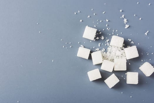 White sugar cube sweet food ingredient and broken, studio shot isolated on a gray background, Minimal health high blood risk of diabetes and calorie intake concept.