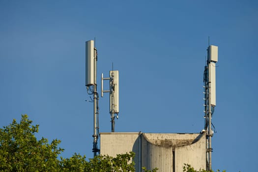 antenna mast with defferent antennas for mobile radio communications in front of blue sky