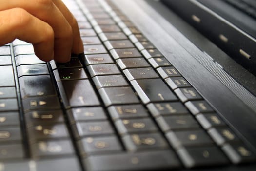 Finger of a female hand press a key on the keyboard of the laptop. Payment Security Concept.