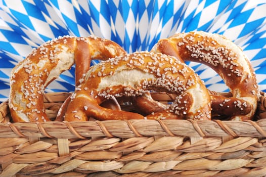 Three original Bavarian lye pretzels with salt in front of Bavarian diamond compartments