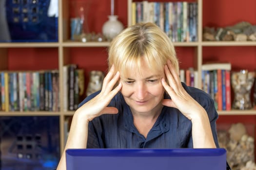 Closeup of the middle aged woman. She is smiling and surprised by what she reads in the notebook. All potential trademarks are removed.