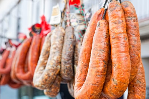 Blood sausages and chorizos hanging over street market stall