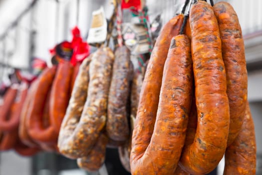 Blood sausages and chorizos hanging over street market stall