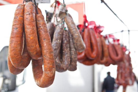 Blood sausages and chorizos hanging over street market stall