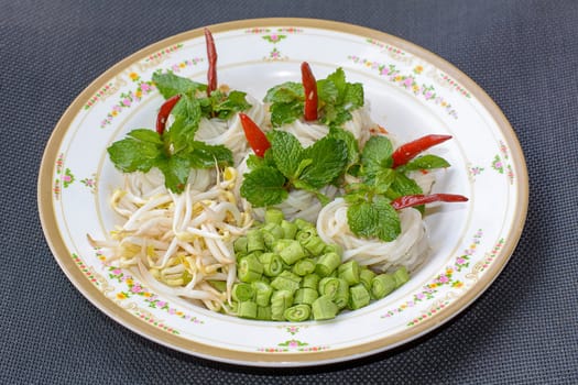 Rice noodles in fish curry sauce with vegetables or  Thai vermicelli eaten with curry is Thai food. The dish is delicious and spicy food.
