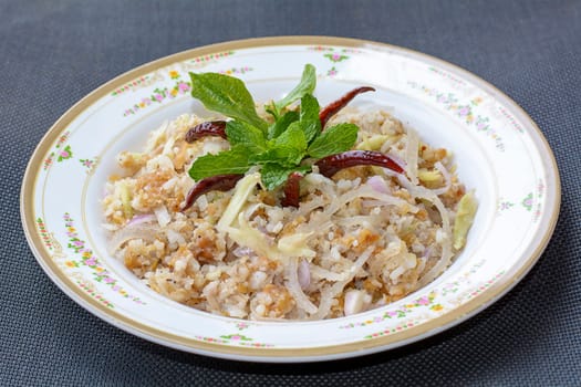 Yam Naem Khao Thot or Spicy Salad of Curried Rice Croquettes, Fermented Pork, Ginger and Peanuts is a great Thai food. The dish is delicious and spicy food.