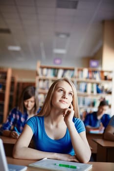 Cute girl daydreaming at lesson in college