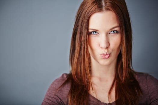 Young woman expressing air kiss while looking at camera