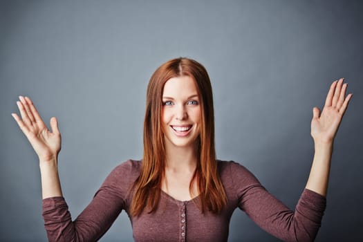 Happy young woman keeping her arms raised up and open