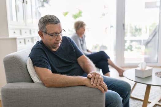 Upset senior couple at home in living room having an argument