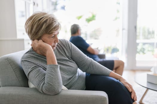 Upset senior couple at home in living room having an argument