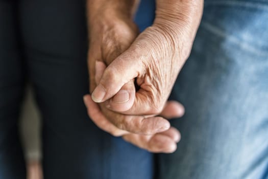 Happy romantic senior couple in love holding hands at home