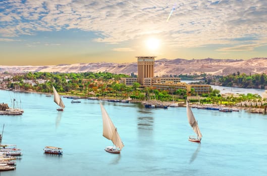 Sailboats of the Nile, beautiful sunset over Aswan city, Egypt.
