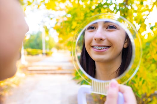 Caucasian girl looking in mirror outside