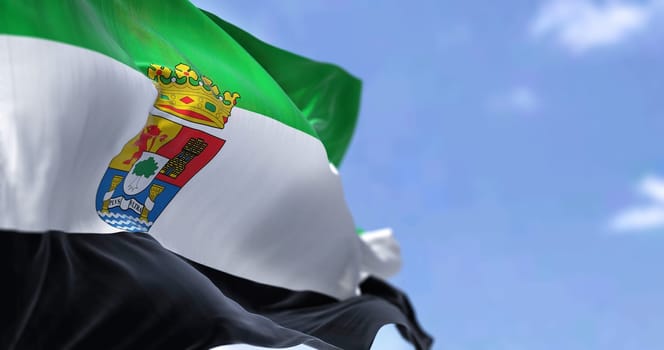 The Extremadura flag waving in the wind on a clear day. The Extremadura is an autonomous community of Spain. Its capital city is Merida
