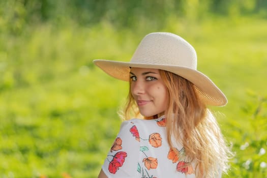 Portrait of attractive  young woman in straw hat looking over the shoulder looking at the camera.