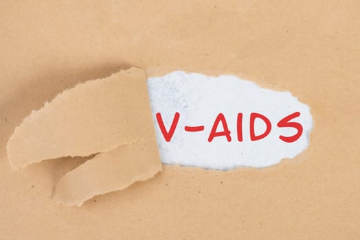 The words v-aids is standing in german language on on torn paper, vaccine damage, new autoimmune disease caused by covid-19 syringe, immune system injury, health issue