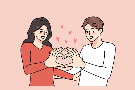 Happy couple show heart hand gesture