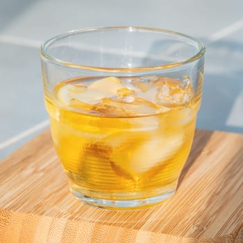 Glass of golden rum on the rocks