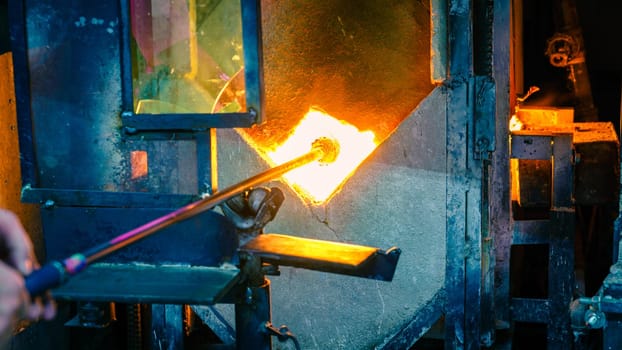 Softening glass in a kiln during glassblowing process