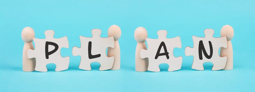 The word plan is standing on puzzle pieces, connect the parts together, corporate in teamwork, cooperating to reach a goal