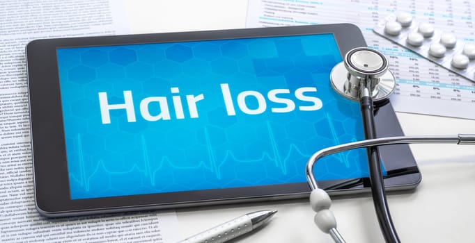 The word Hair loss on the display of a tablet
