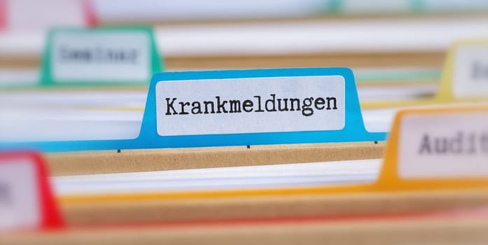 File folders with a tab labeled Sick leaves in german - Krankmeldungen
