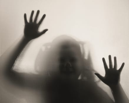 Horror ghost girl behind the matte glass in black and white. Halloween festival concept.