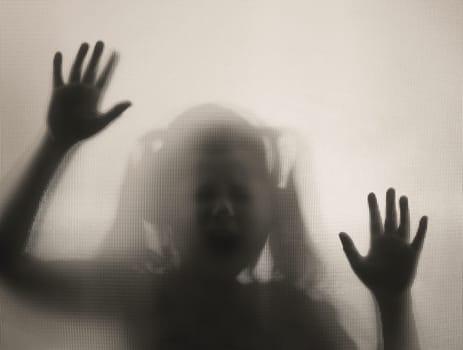 Horror ghost girl behind the matte glass in black and white. Halloween festival concept.