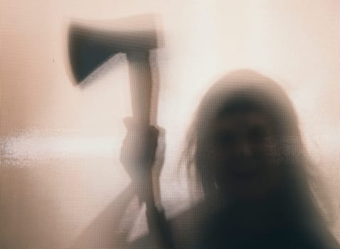 Horror, halloween background - Shadowy figure behind glass of a woman holding an axe