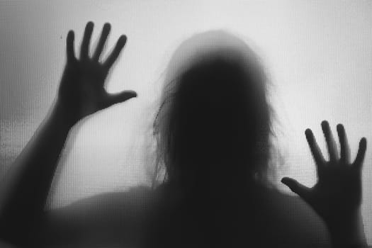 Horror ghost woman behind the matte glass in black and white. Halloween festival concept.