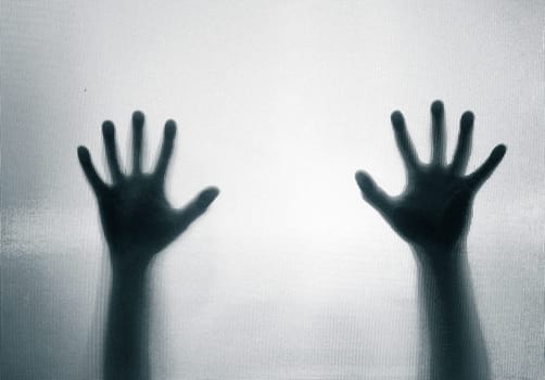 Horror, halloween background - Shadowy figure hands behind glass