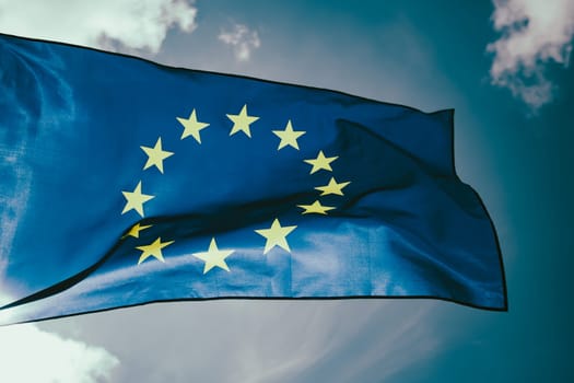 Waving European Union flag on blue sky.