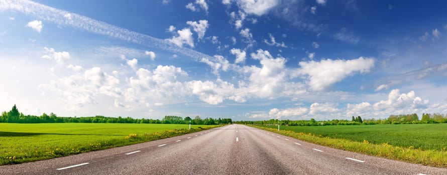Panoramic view of the curve asphalt road in spring in nature. Springtime in natural park. Empty highway.