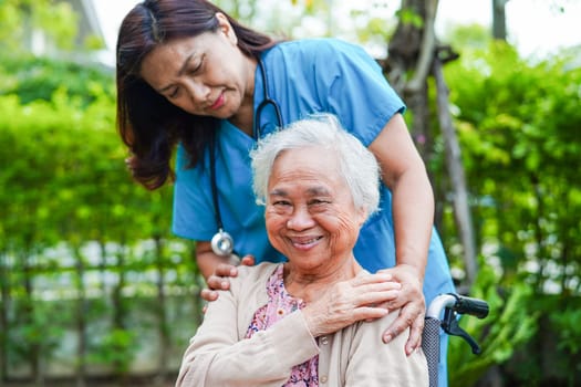 Doctor help Asian elderly woman disability patient sitting on wheelchair in park, medical concept.