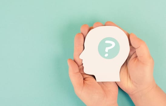 Holding a head with a question mark in the hands, education and business concept, searching for answers, thoughts for solving a problem, man has doubts