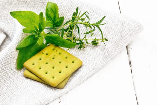 Dry cookies with spinach, rosemary and thyme on a napkin against a light wooden board background