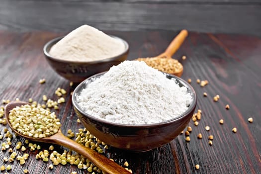 Buckwheat flour from green and brown cereals in two bowls, groats in spoons and on the table against the background of a dark wooden board