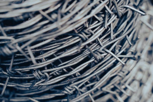 macro closeup of large roll of steel barbed wire used for fence construction