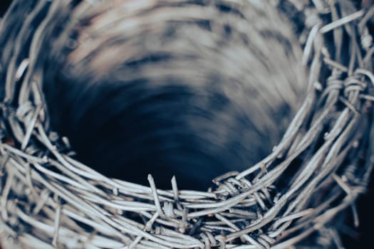 macro closeup of large roll of steel barbed wire used for fence construction