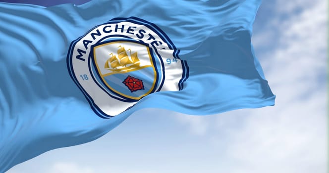 Manchester, UK, May 2022: The flag of Manchester City Football Club waving in the wind on a clear day. Manchester F.C. is a professional football club based in Bradford, Manchester