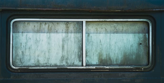front view closeup of old rusted car window with metallic chrome frame and dirty opaque glass rectangular shape