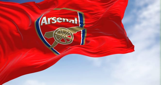 London, UK, May 2022: The flag of Arsenal Football Club waving in the wind on a clear day. Arsenal is a professional football club based in Islington, London, England
