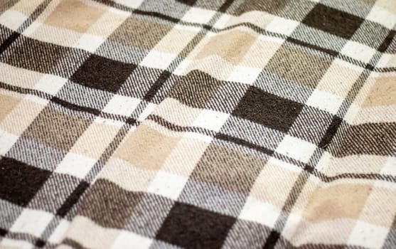 Blanket. Texture of checkered wool fabric in brown color. Checkered texture. Warm brown alpaca wool or cashmere blanket. Beige, brown square shaped wool fabric for home design