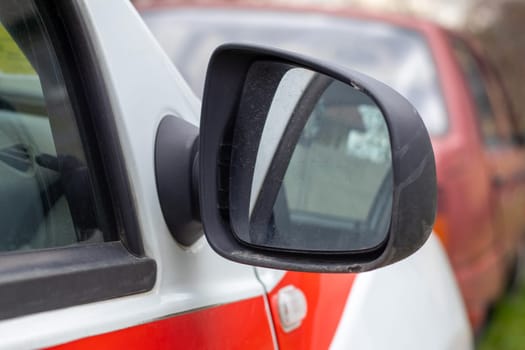 Side right black plastic rearview mirror on a white car. Exterior side view mirror on the passenger side, electrically adjustable and heated
