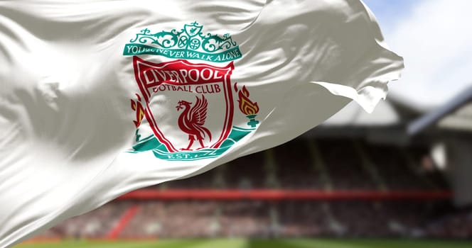 Liverpool, UK, May 2022: The flag of Liverpool Football Club waving in the wind with Anfield stadium blurred in the background. Liverpool is a professional football club based in Liverpool, England