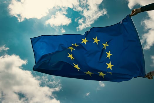 Waving European Union flag on blue sky.